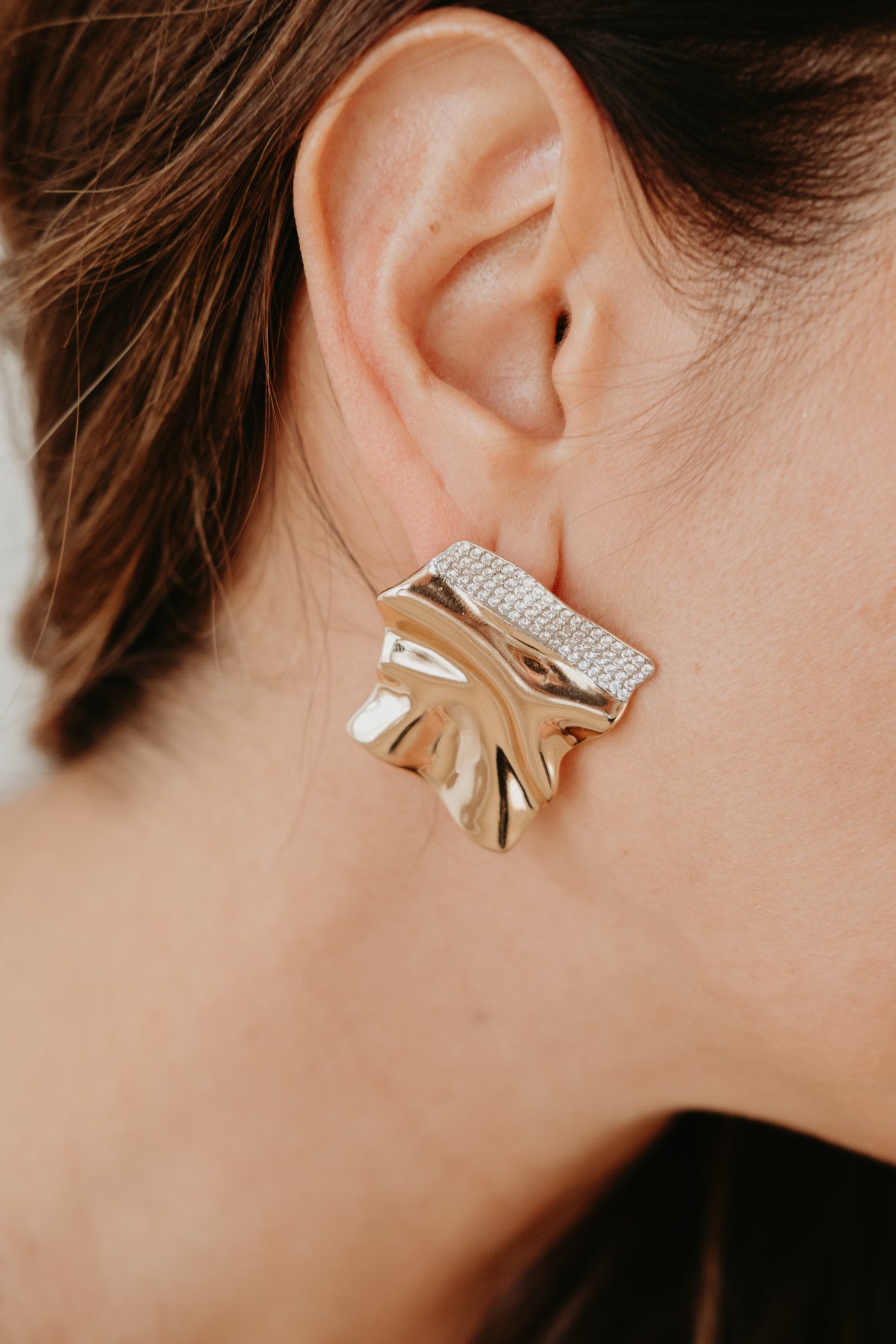 Sculptural 18K gold plated earrings with polished curved surfaces and brilliant zirconia accented edges