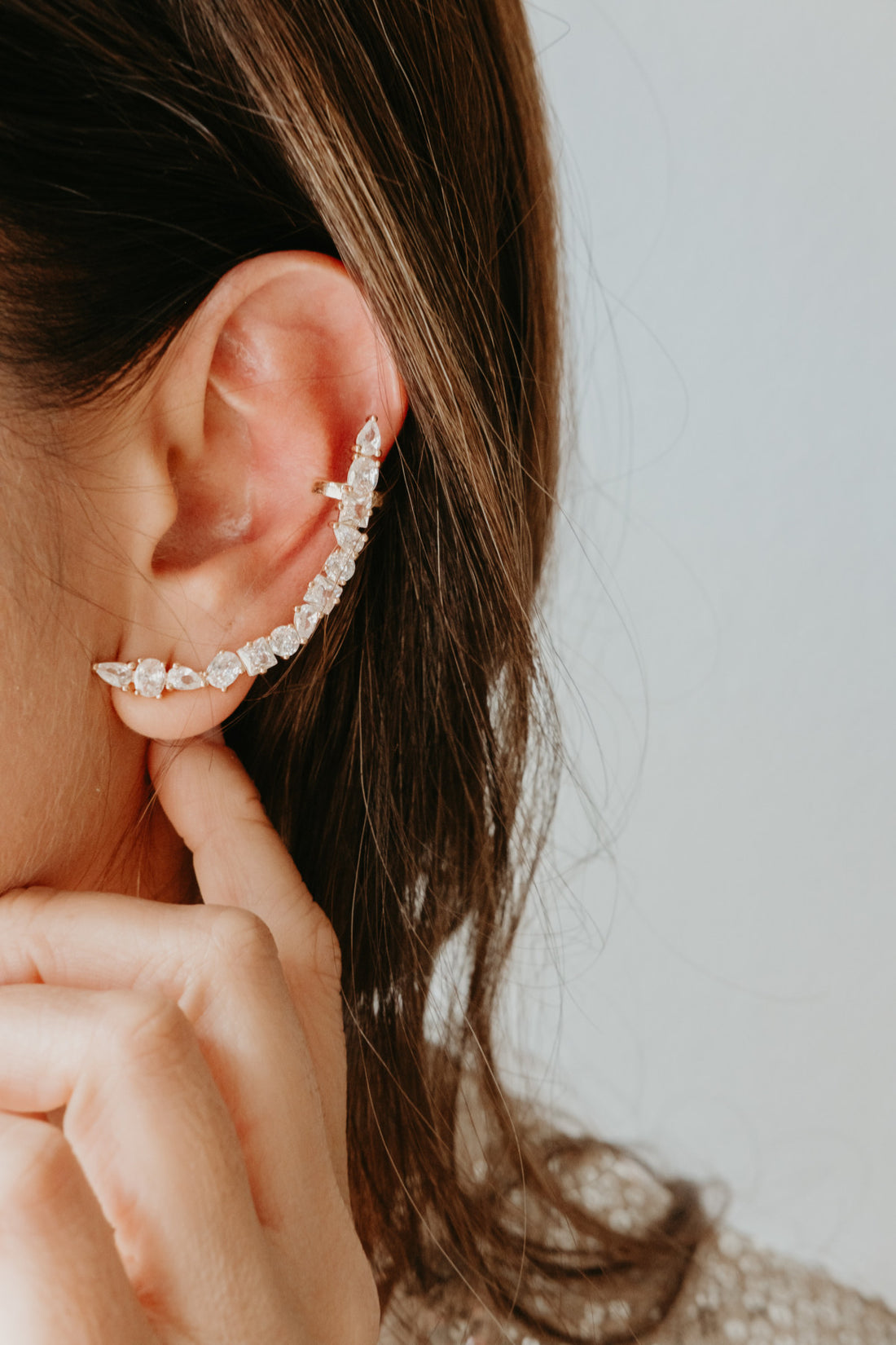 Gold zirconia ear climber earrings featuring mixed stone shapes and a sculptural full ear silhouette